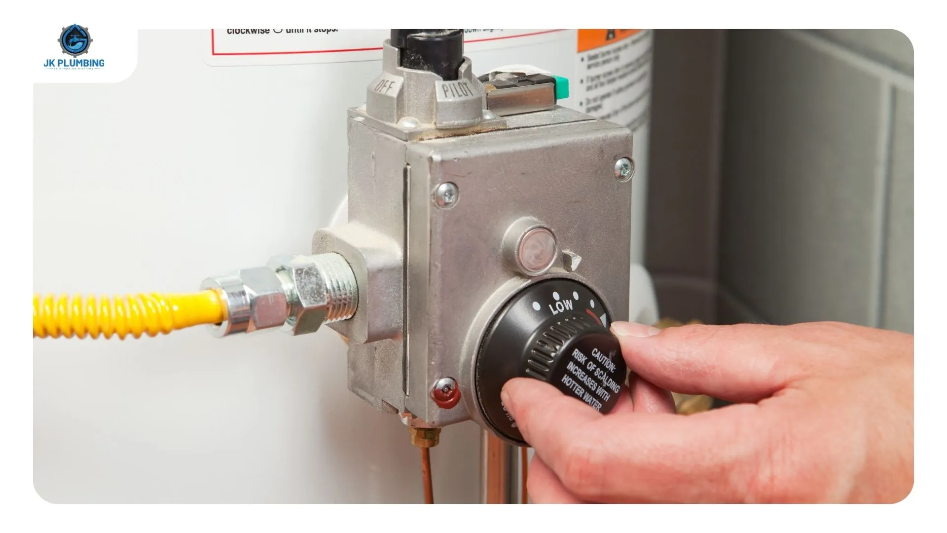 Red high-limit reset button and upper thermostat exposed behind the access panel of an electric water heater