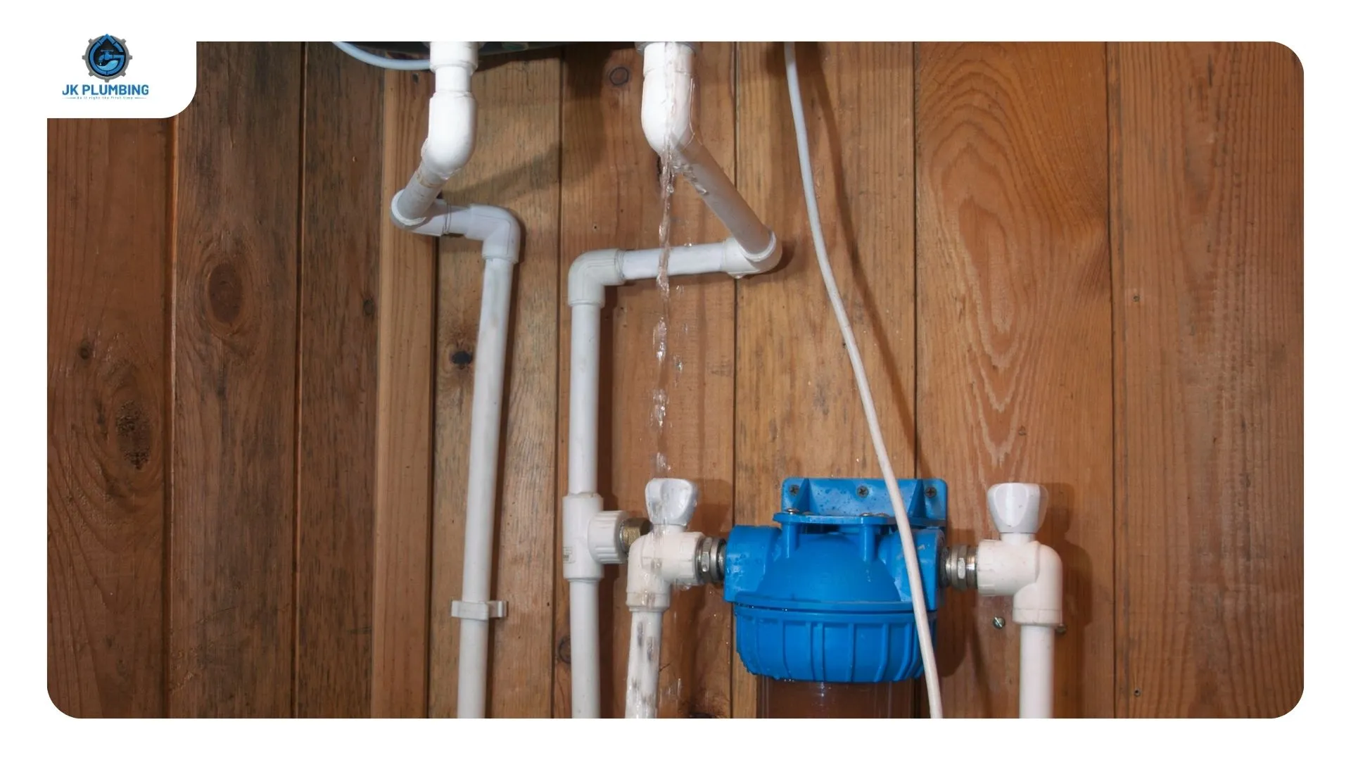 Red high-limit reset button and upper thermostat behind the access panel of an electric water heater
